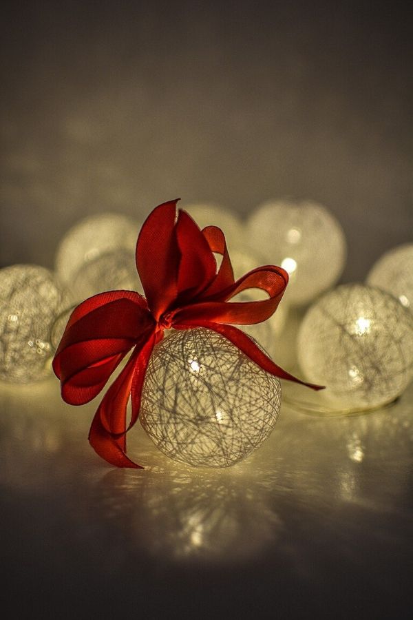 A picture of a lighted Christmas ball with a red bow for this post about a simple Christmas.