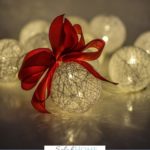 A Pinterest pin with a picture of a lighted Christmas ball with a red bow. Designed for this post about a simple Christmas.