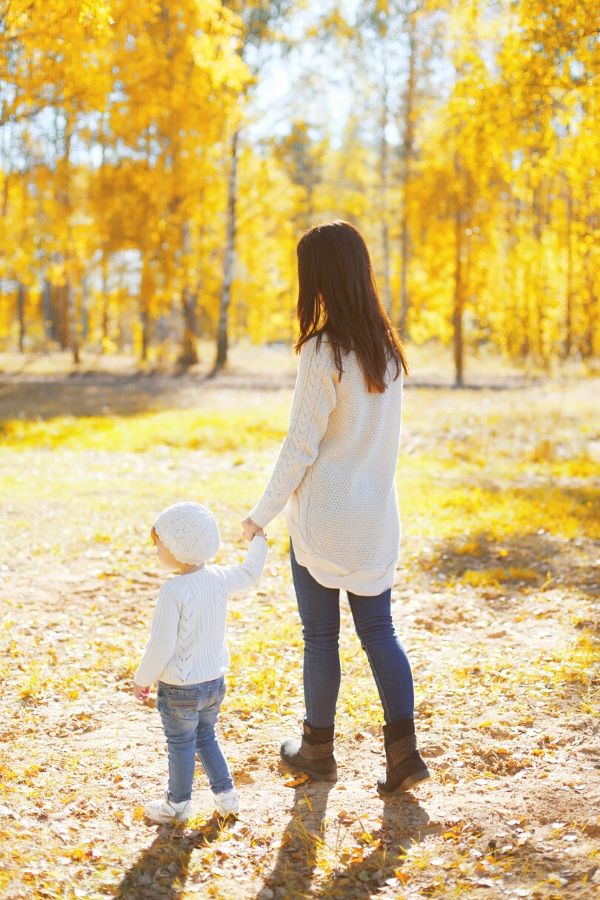 A picture of a woman and small child walking through a field for this post about simple and inexpensive parent and child bonding activities.
