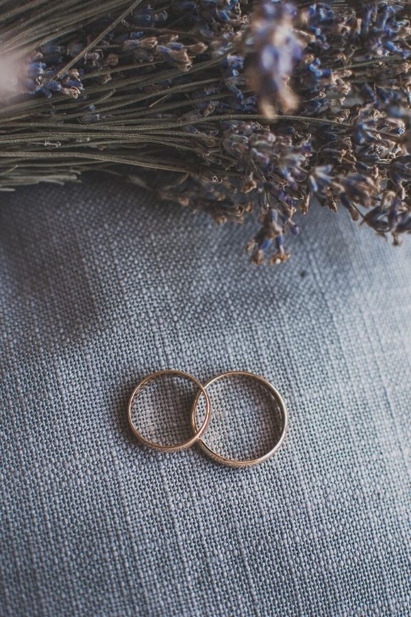 A picture of two wedding rings beside blue flowers for this post about the importance of a love without conditions in marriage.