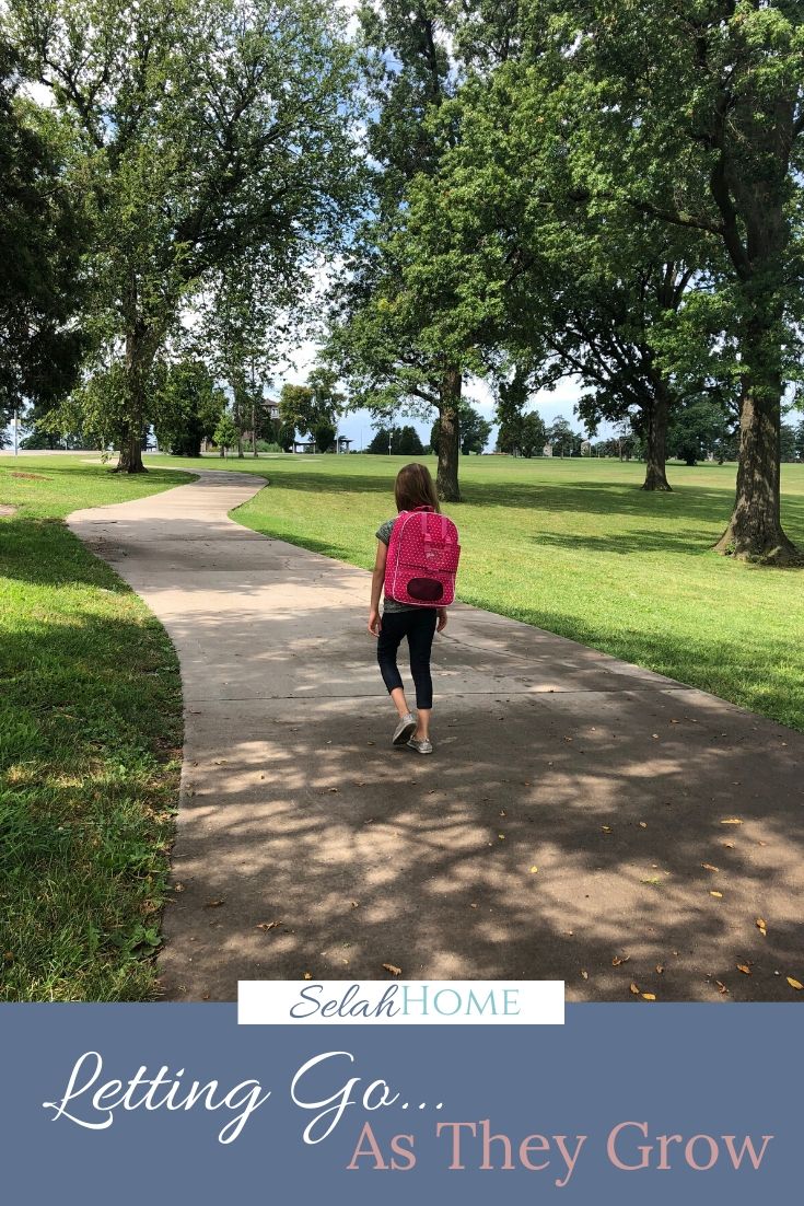 A Pinterest pin with a picture of a girl with a backpack walking down the sidewalk. Designed for this post about letting go on the first day of kindergarten.