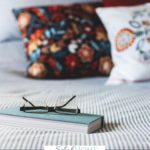 A Pinterest pin with a picture of a notebook and reading glasses sitting on a bed. Designed for this post on Christian marriage advice.