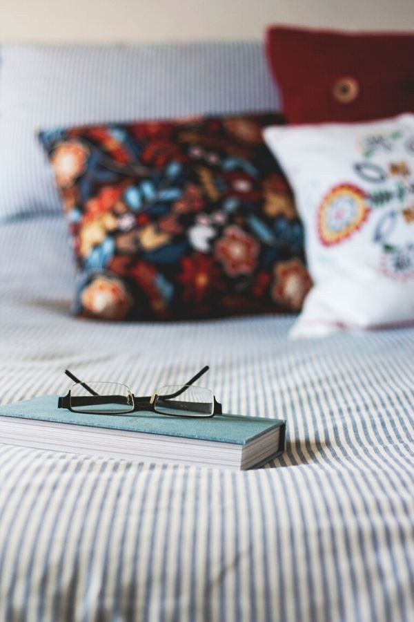 A picture of a notebook and reading glasses sitting on a bed for this post on christian marriage advice.