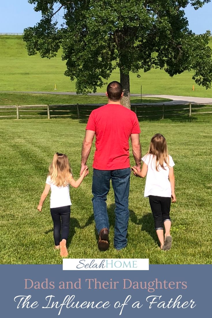 A Pinterest pin with a picture of my husband walking hand in hand through an open field with our two daughters. Designed for this post about dads and their daughters.