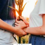 A Pinterest pin with a picture of a couple holding hands in a wheat field. Designed for this post about personality differences in marriage.