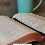 A Pinterest pin with a picture of an open Bible sitting by a coffee cup. Designed for this post about scriptures on fear.