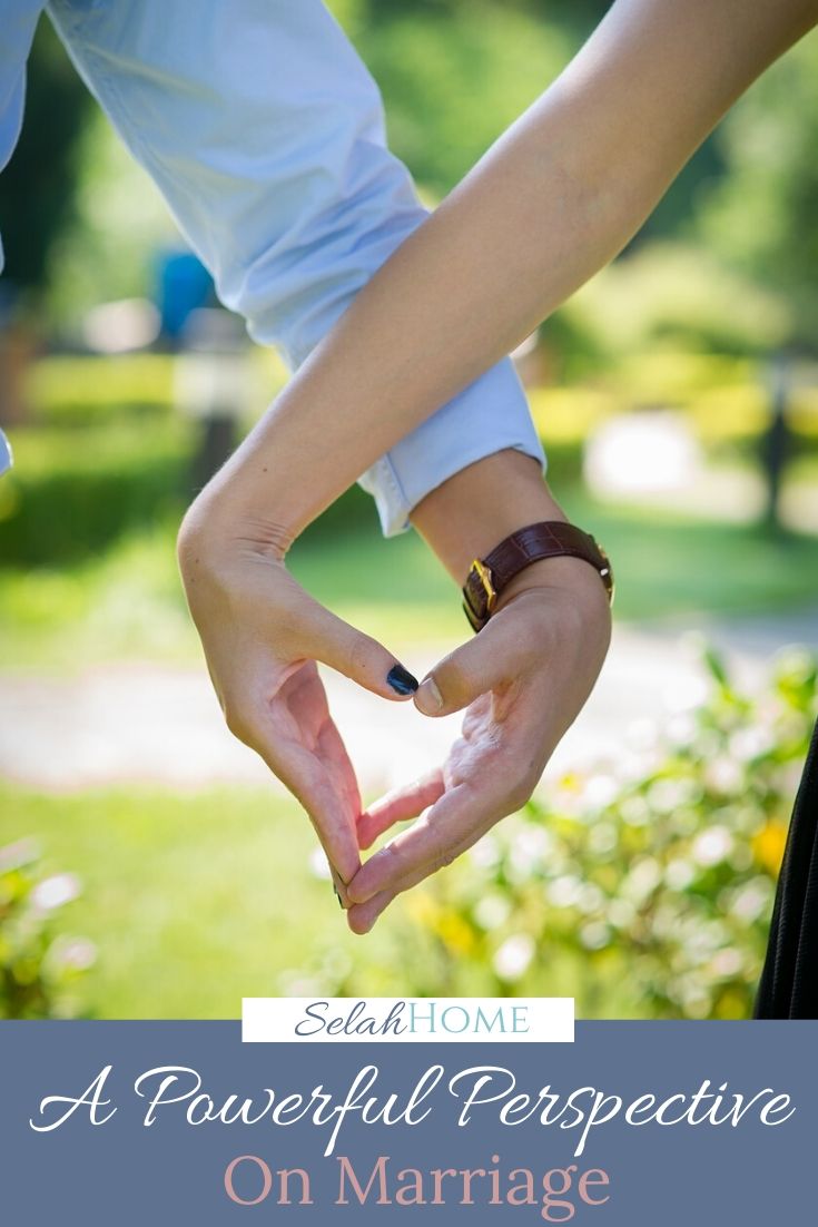 A Pinterest pin with a picture of a a couple making a heart with their hands. Designed for this post on marriage perspective.