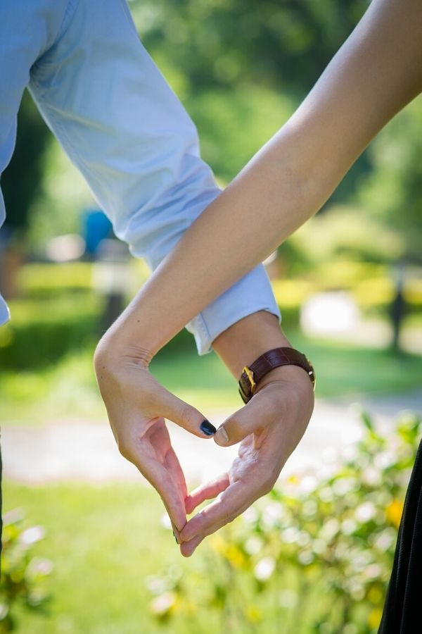 A picture of a couple making a heart with their hands for this post on marriage perspective.