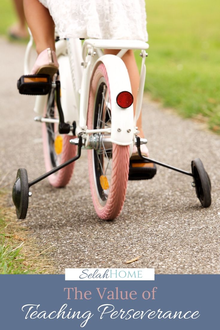 A Pinterest pin with a picture of a child riding a bike. Designed for this post about building perseverance for kids.