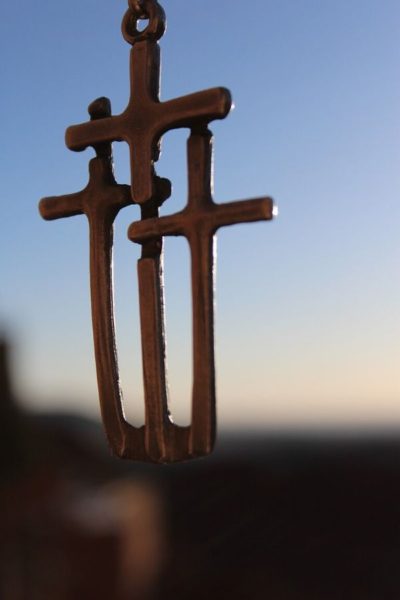 A picture of three crosses on a necklace for this post of verses about obedience to God.