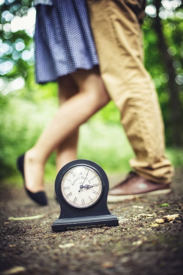 A picture of a couple dancing outside beside a clock for this post about ideas for simple and inexpensive date nights for parents.
