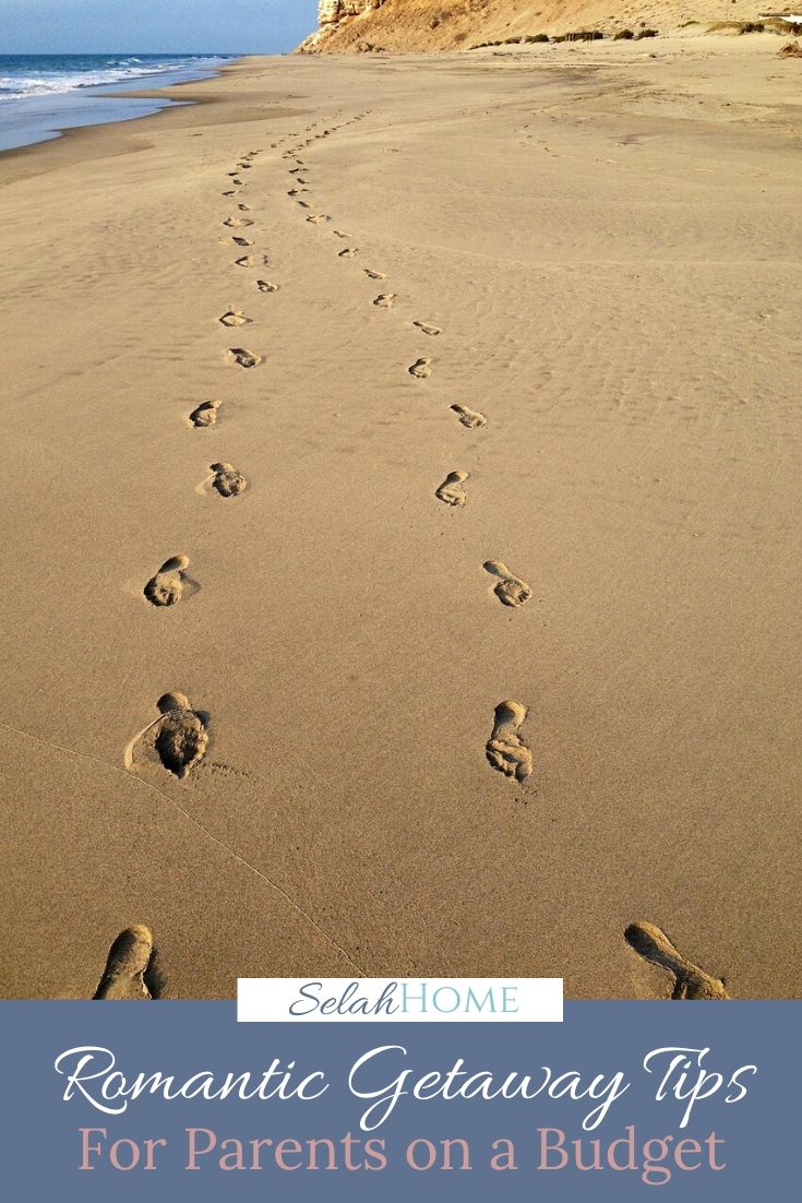 A Pinterest pin with a picture of a pair of footprints in the sand. Designed for this post of romantic getaway tips for parents on a budget.