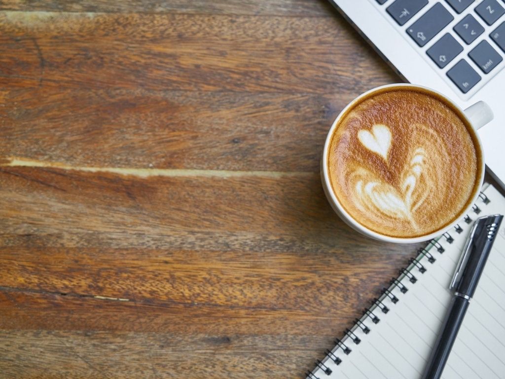 A picture of a coffee cup, computer, and notebook for this post about five of the best blogs with encouragement for moms.