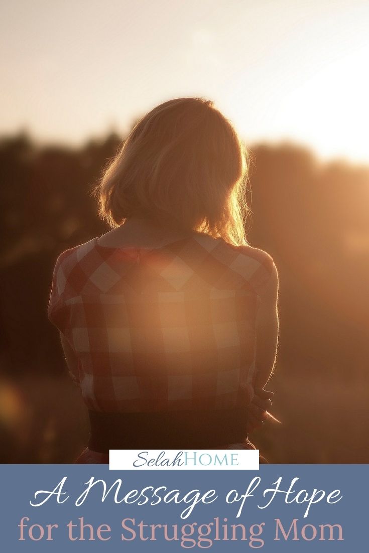 A Pinterest pin with a picture of a discouraged woman at sunset. Designed for this post about hope for the struggling mom.