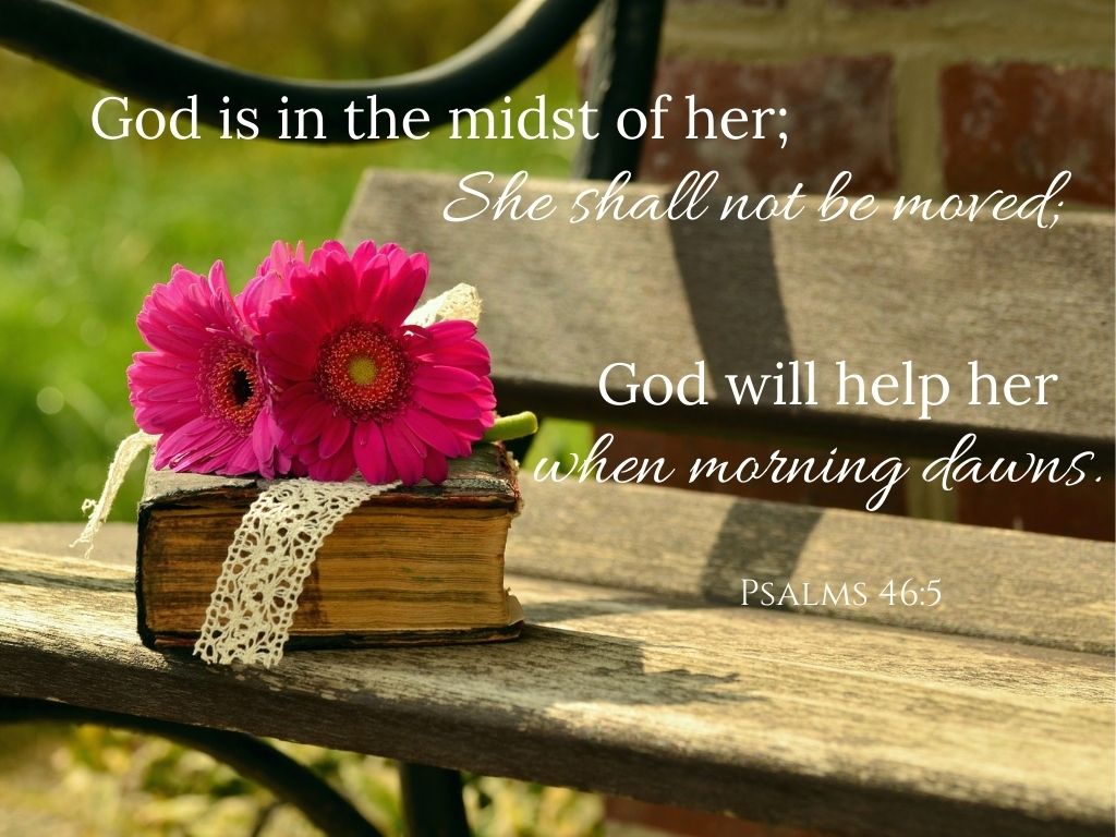 A picture of an old Bible and pink flowers sitting on a bench for this post of scriptures for moms. A bible verse across the picture reads, "God is in the midst of her; She shall not be moved; God will help her when morning dawns." Psalms 46:5