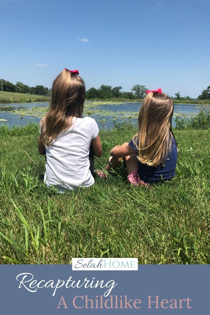 A Pinterest pin with a picture of two little girls looking out over a pond. Designed for this post about a childlike heart.