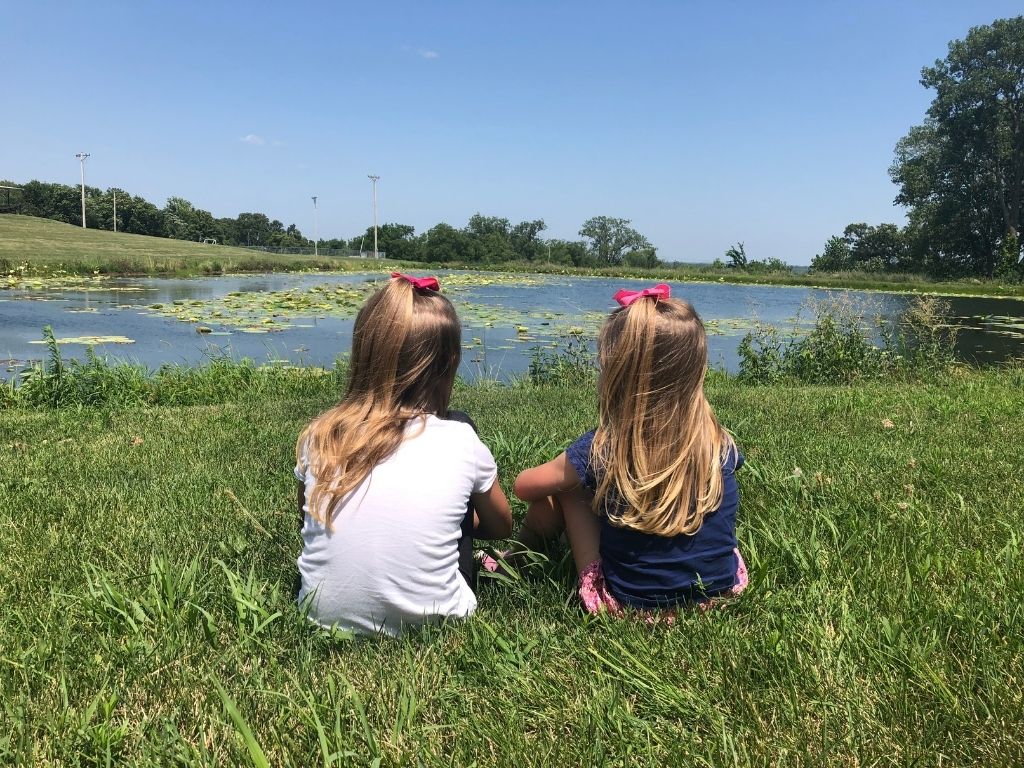 A picture of two little girls looking out over a pond for this post about a childlike heart.