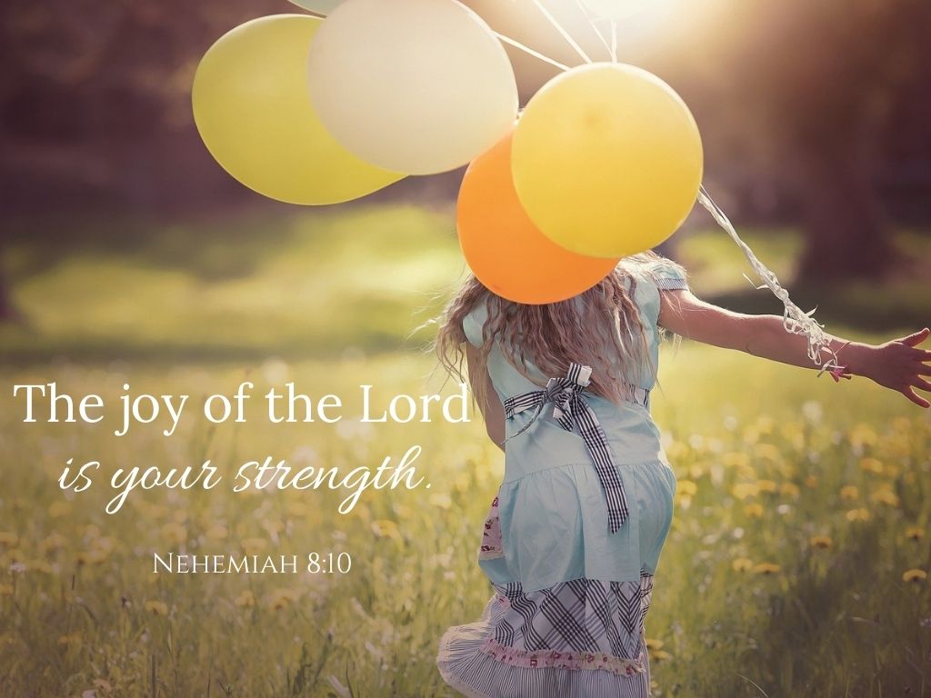 A picture of a girl holding balloons and running through a field for this post of bible verses about choosing joy.
