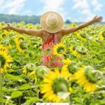 A Pinterest pin with a picture of a woman in a field of sunflowers. Designed for this post about how to keep your joy.