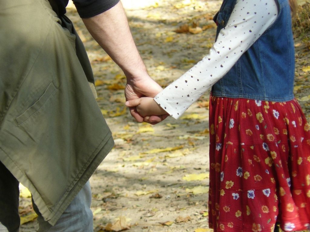 A picture of a father and daughter holding hands for this post about the value of daddy daughter dates.