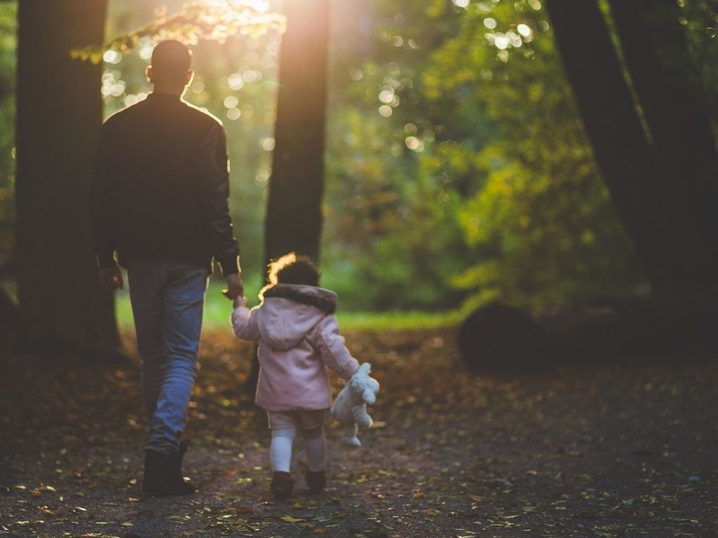 A picture of a father and daughter taking a walk for this post of daddy-daughter date ideas.