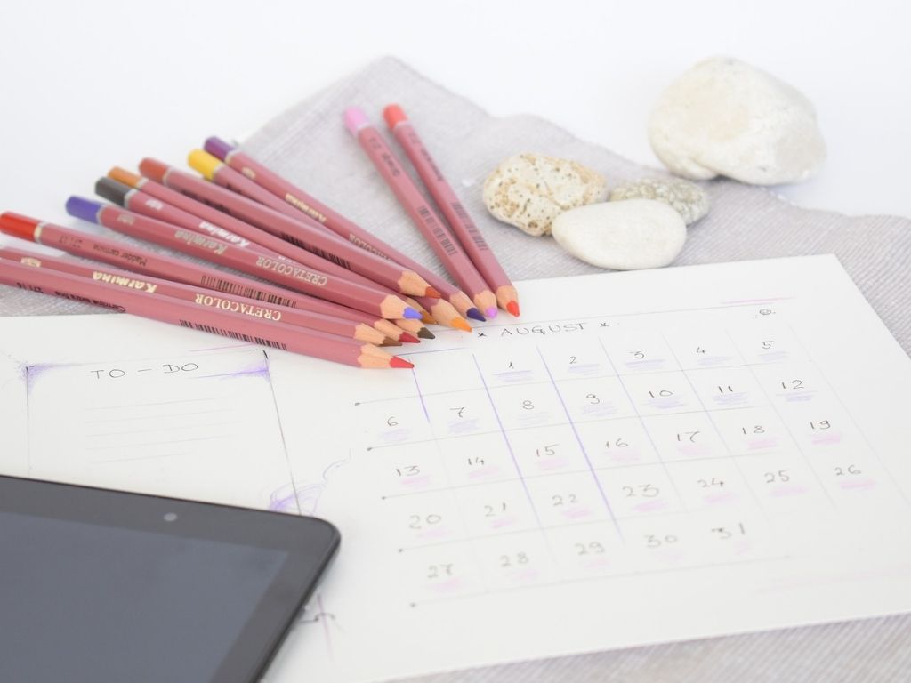 A picture of a calendar, to-do list, and pencils for this post about a list of chores for kids.