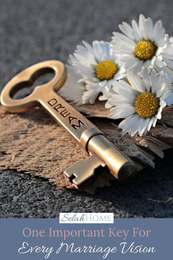 A Pinterest pin with a picture of white flowers and a key with the word dream engraved on it. Designed for this post about marriage vision.