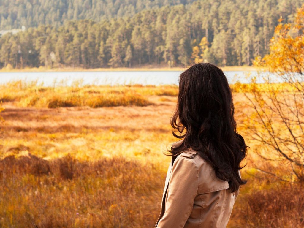 A picture of a woman looking out over an open field for this post about waiting on God.