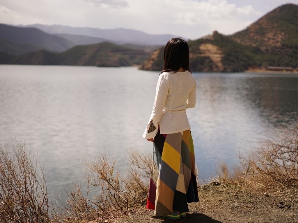 A picture of a woman looking over a lake for this post about the benefits of waiting upon the Lord.