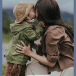 A Pinterest pin with a picture of a little girl kissing her mom's cheek . Designed for this post about being a present parent.