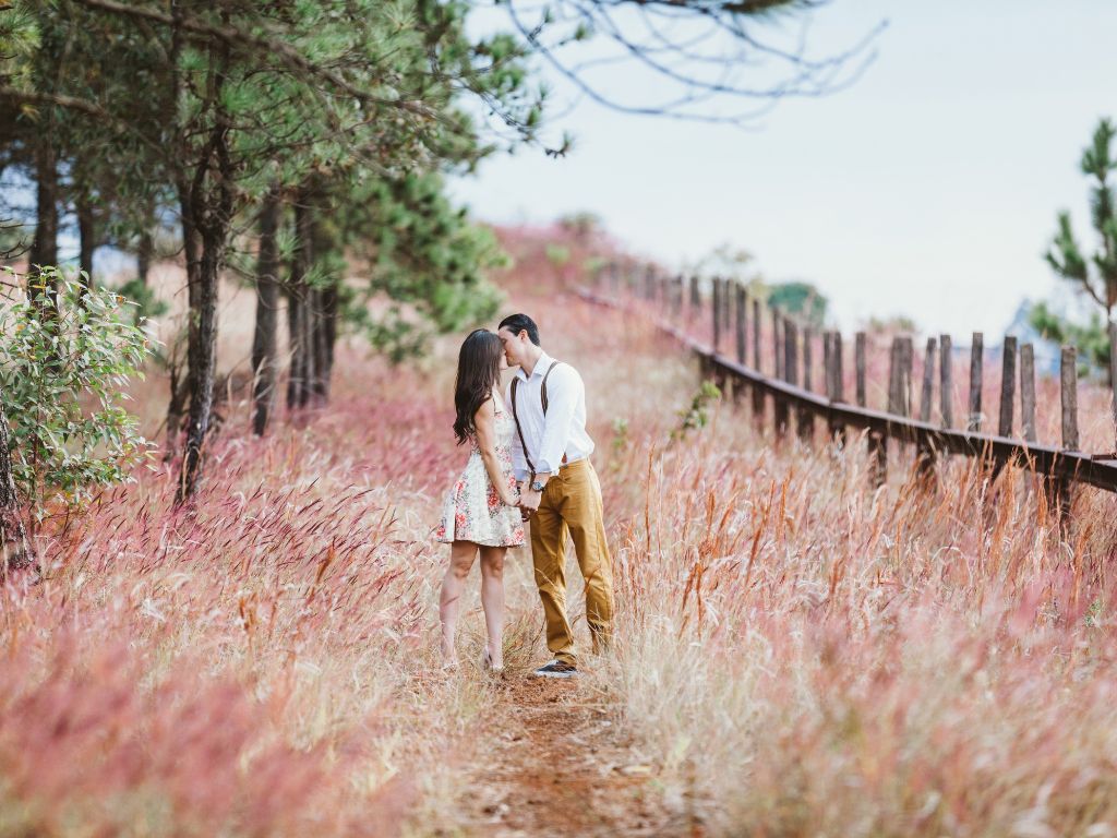 A picture of a couple kissing in a field for this post of strong marriage quotes.